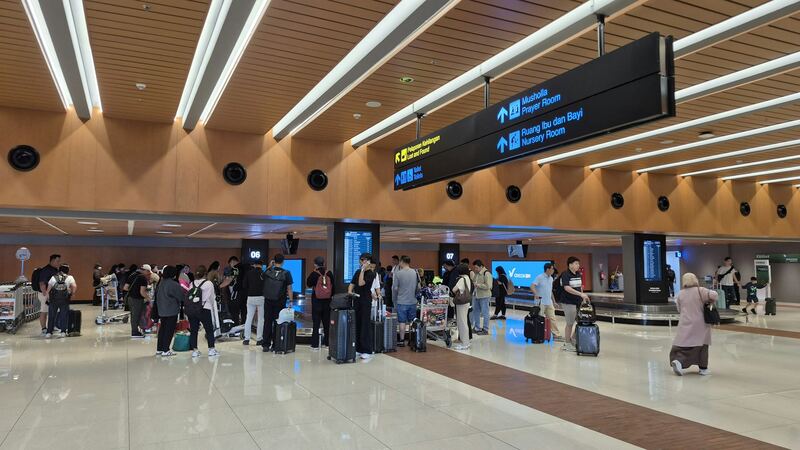 Travellers with luggage in an airport hall (example photo)